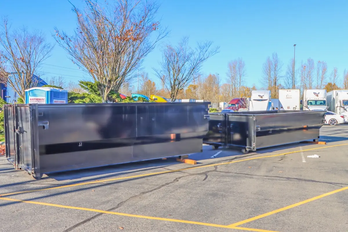 Professional dumpster rental service with roll-off container on residential driveway in Rose